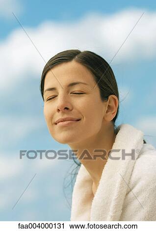 Woman wearing bathrobe, smiling with eyes closed, sky in background View Large Photo Image Stock Image - Woman wearing bathrobe, smiling with eyes closed, sky in background. Fotosearch