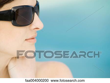 Woman wearing dark sunglasses, side view View Large Photo Image Stock Image - Woman wearing dark sunglasses, side view. Fotosearch