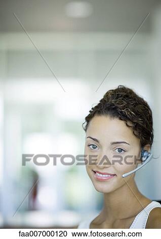 Stock Image - Woman wearing headset. Fotosearch
