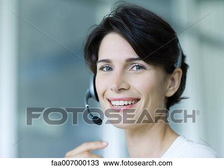 Stock Image - Woman wearing headset. Fotosearch