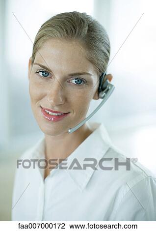 Stock Image - Woman wearing headset. Fotosearch