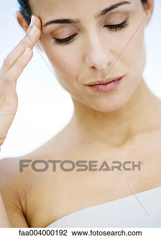 Woman with fingers on side of head and eyes lowered View Large Photo Image Stock Image - Woman with fingers on side of head and eyes lowered. Fotosearch