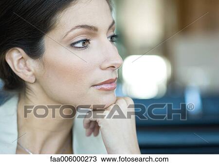 Stock Image - Woman with hand under chin, close-up, portrait. Fotosearch