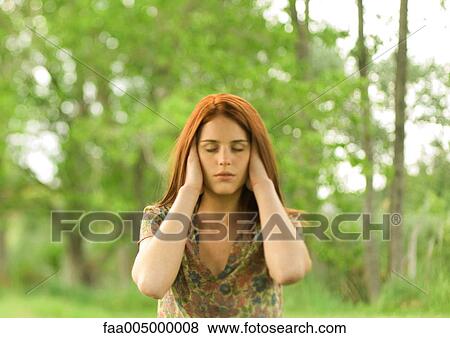 Woman with hands over ears and eyes shut, outdoors View Large Photo Image Stock Photo - Woman with hands over ears and eyes shut, outdoors. Fotosearch