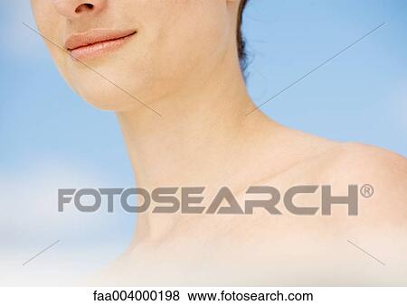 Stock Photo - Woman's lower face and shoulder, sky in background. Fotosearch
