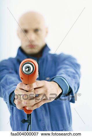 Worker holding out drill View Large Photo Image Stock Photo - Worker holding out drill. Fotosearch