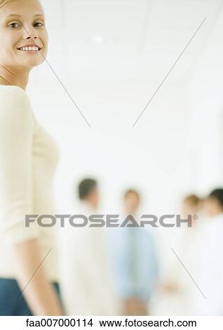 Young businesswoman, colleagues standing in background View Large Photo Image Picture - Young businesswoman, colleagues standing in background. Fotosearch
