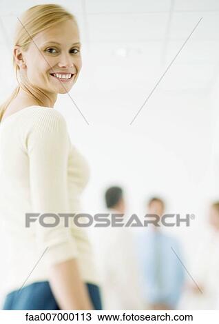 Young businesswoman, colleagues standing in background View Large Photo Image Stock Image - Young businesswoman, colleagues standing in background. Fotosearch