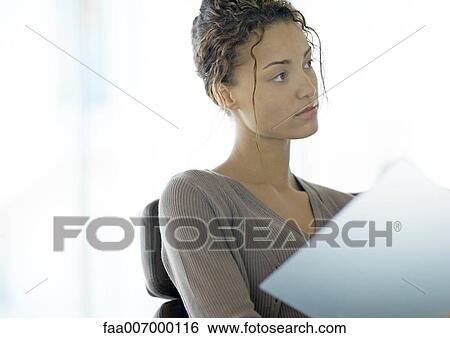 Young businesswoman looking up from file View Large Photo Image Stock Photograph - Young businesswoman looking up from file. Fotosearch