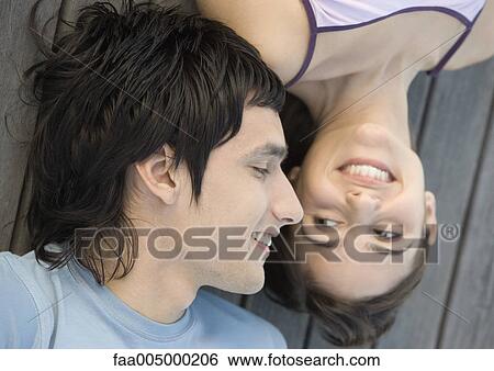 Young couple lying on dock, close-up View Large Photo Image Stock Photograph - Young couple lying on dock, close-up. Fotosearch