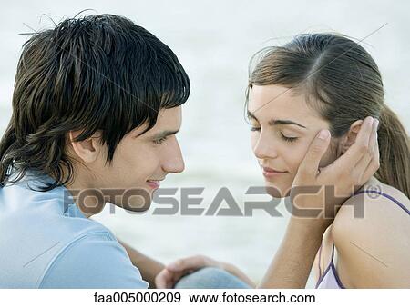 Young couple, man touching woman's face View Large Photo Image Stock Photo - Young couple, man touching woman's face. Fotosearch