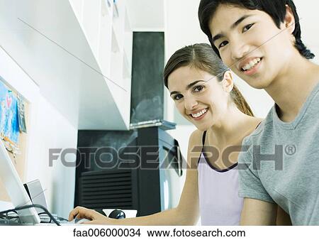 Young couple sitting at computer View Large Photo Image Picture - Young couple sitting at computer. Fotosearch