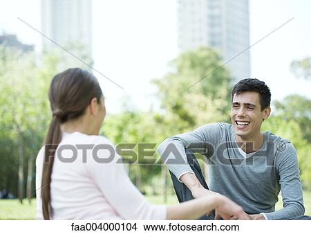Young couple sitting in city park View Large Photo Image Picture - Young couple sitting in city park. Fotosearch