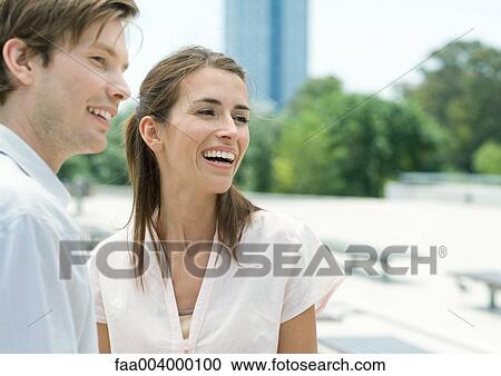 Young couple smiling in city park View Large Photo Image Stock Image - Young couple smiling in city park. Fotosearch