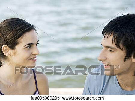 Stock Photography - Young couple, water in background. Fotosearch