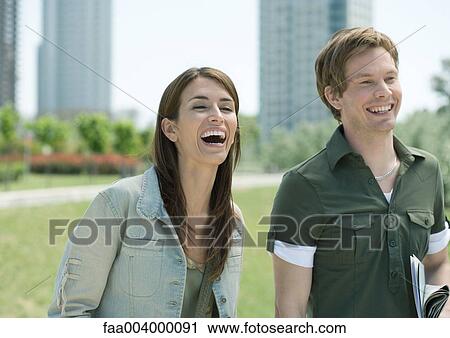 Young man and woman in city park, laughing View Large Photo Image Stock Image - Young man and woman in city park, laughing. Fotosearch