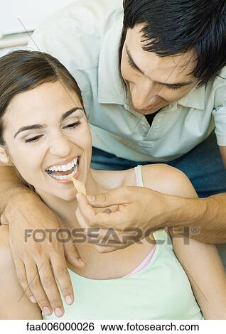 Young man feeding girlfriend chip View Large Photo Image Stock Photograph - Young man feeding girlfriend chip. Fotosearch