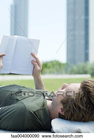 Young man reading in city park, close-up View Large Photo Image Stock Image - Young man reading in city park, close-up. Fotosearch