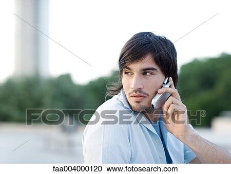Young man using cell phone View Large Photo Image Stock Image - Young man using cell phone. Fotosearch