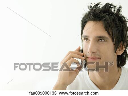 Young man using cell phone View Large Photo Image Stock Image - Young man using cell phone. Fotosearch