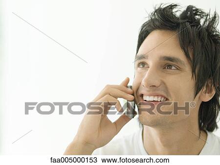 Young man using cell phone View Large Photo Image Stock Image - Young man using cell phone. Fotosearch