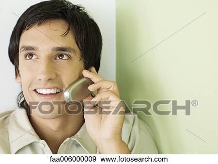 Young man using cell phone View Large Photo Image Stock Photo - Young man using cell phone. Fotosearch