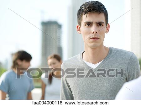 Young man with serious expression on college campus View Large Photo Image Stock Photograph - Young man with serious expression on college campus. Fotosearch