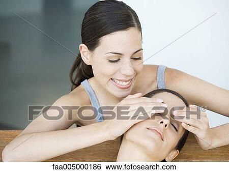 Young woman holding hands over friends eyes from behind View Large Photo Image Stock Photograph - Young woman holding hands over friends eyes from behind. Fotosearch