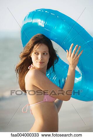 Young woman holding innertube View Large Photo Image Stock Image - Young woman holding innertube. Fotosearch