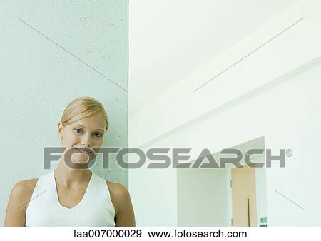 Young woman leaning against wall View Large Photo Image Stock Photo - Young woman leaning against wall. Fotosearch