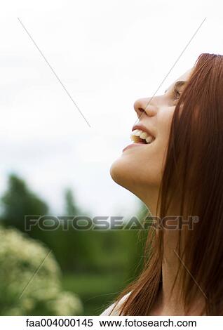 Young woman looking up and smiling View Large Photo Image Stock Photography - Young woman looking up and smiling. Fotosearch