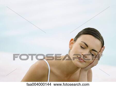 Young woman resting head on hand View Large Photo Image Picture - Young woman resting head on hand . Fotosearch