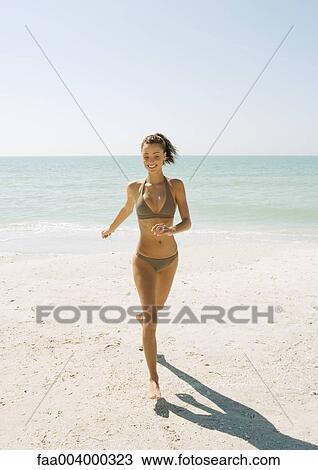 Young woman running on beach View Large Photo Image Stock Image - Young woman running on beach. Fotosearch
