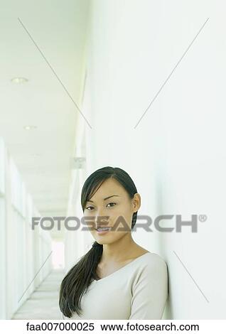 Stock Photography - Young woman standing in corridor. Fotosearch
