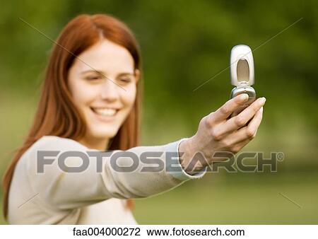 Young woman taking photo with cell phone View Large Photo Image Stock Image - Young woman taking photo with cell phone. Fotosearch
