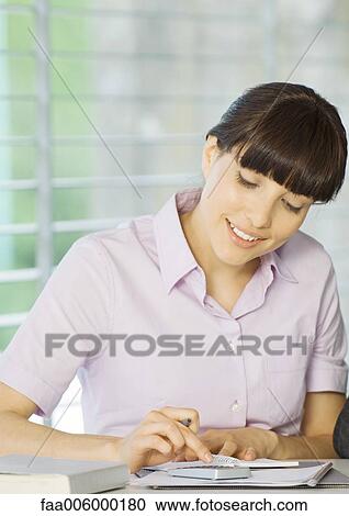 Young woman using calculator View Large Photo Image Stock Image - Young woman using calculator. Fotosearch