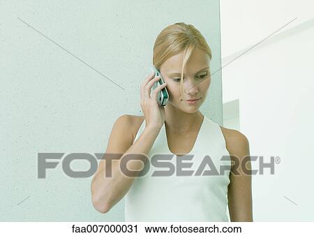 Stock Image - Young woman using cell phone. Fotosearch