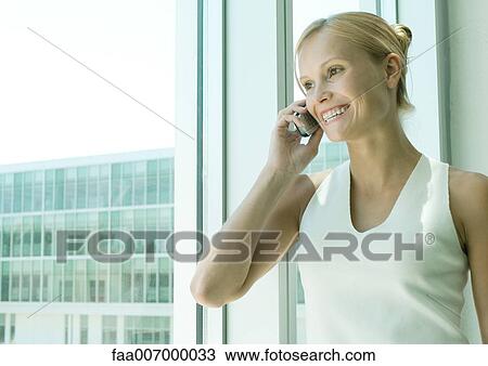 Stock Image - Young woman using cell phone. Fotosearch