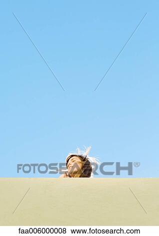 Young woman with hair blowing, low angle view View Large Photo Image Stock Photo - Young woman with hair blowing, low angle view. Fotosearch