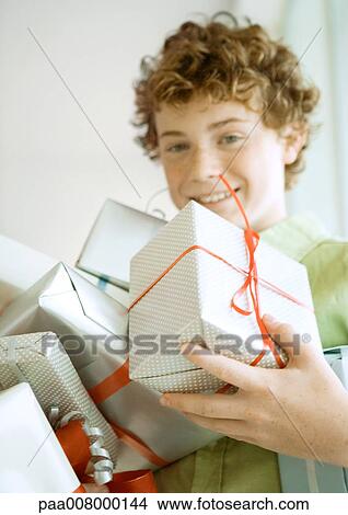 Picture - Boy holding armful of presents. Fotosearch