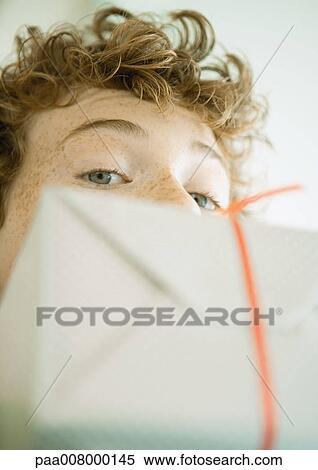 Stock Photography - Boy looking over edge of present. Fotosearch