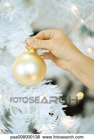 Stock Photo - Child putting ornament on christmas tree. Fotosearch