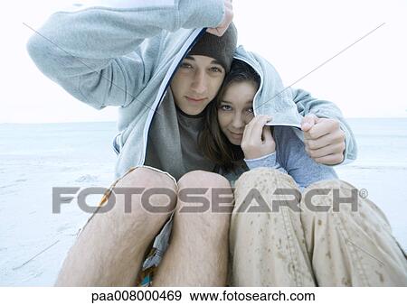 Couple covering heads with jacket in the rain, on beach View Large Photo Image Stock Photo - Couple covering heads with jacket in the rain, on beach. Fotosearch