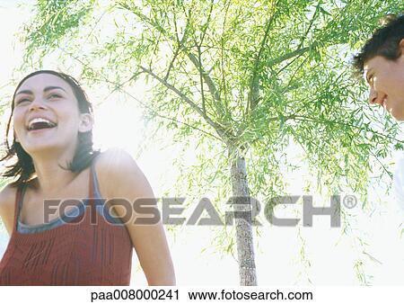 Couple laughing outdoors View Large Photo Image Stock Image - Couple laughing outdoors. Fotosearch