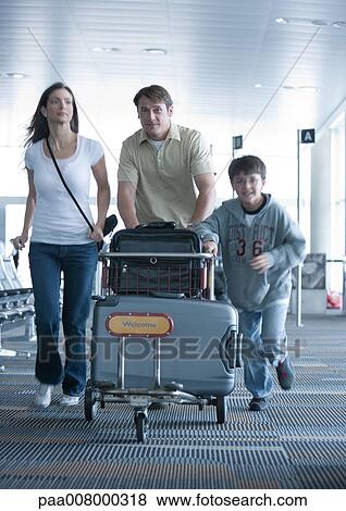 Family hurrying through airport with luggage cart View Large Photo Image Stock Photo - Family hurrying through airport with luggage cart. Fotosearch
