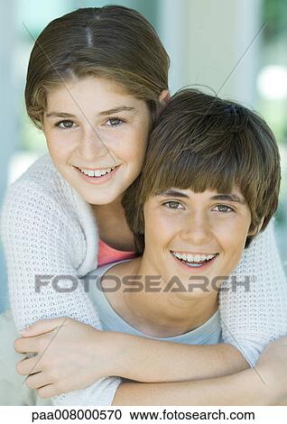 Girl hugging preteen boy from behind, portrait View Large Photo Image Stock Image - Girl hugging preteen boy from behind, portrait. Fotosearch