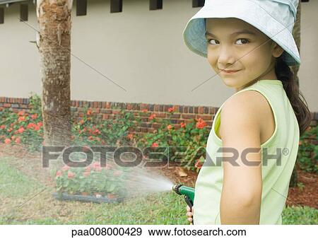 Girl watering plants View Large Photo Image Stock Photo - Girl watering plants. Fotosearch