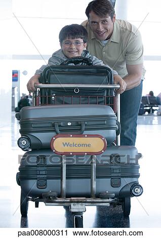 Man and boy pushing luggage cart View Large Photo Image Stock Image - Man and boy pushing luggage cart. Fotosearch