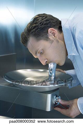 Man drinking from water fountain View Large Photo Image Stock Image - Man drinking from water fountain. Fotosearch