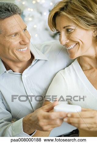 Man giving woman christmas gift View Large Photo Image Stock Photo - Man giving woman christmas gift. Fotosearch